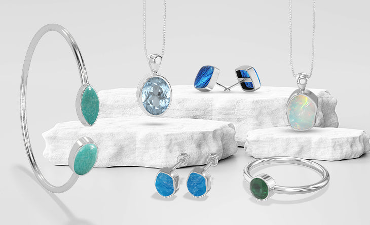 Natural gemstone jewellery displayed on white stone plinths